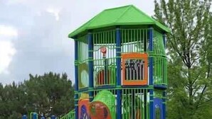 Ein Spielplatz mit einer Spielgeräte-Kombination mit Gründach, Rutschen und Kletterbereichen.