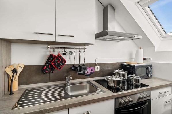 A modern kitchen with a skylight, stainless steel appliances, and a hanging pot rack. - MOLA Apartments-Klimaanlage, Zentrum,Balkon,Seenah (Herdecke)