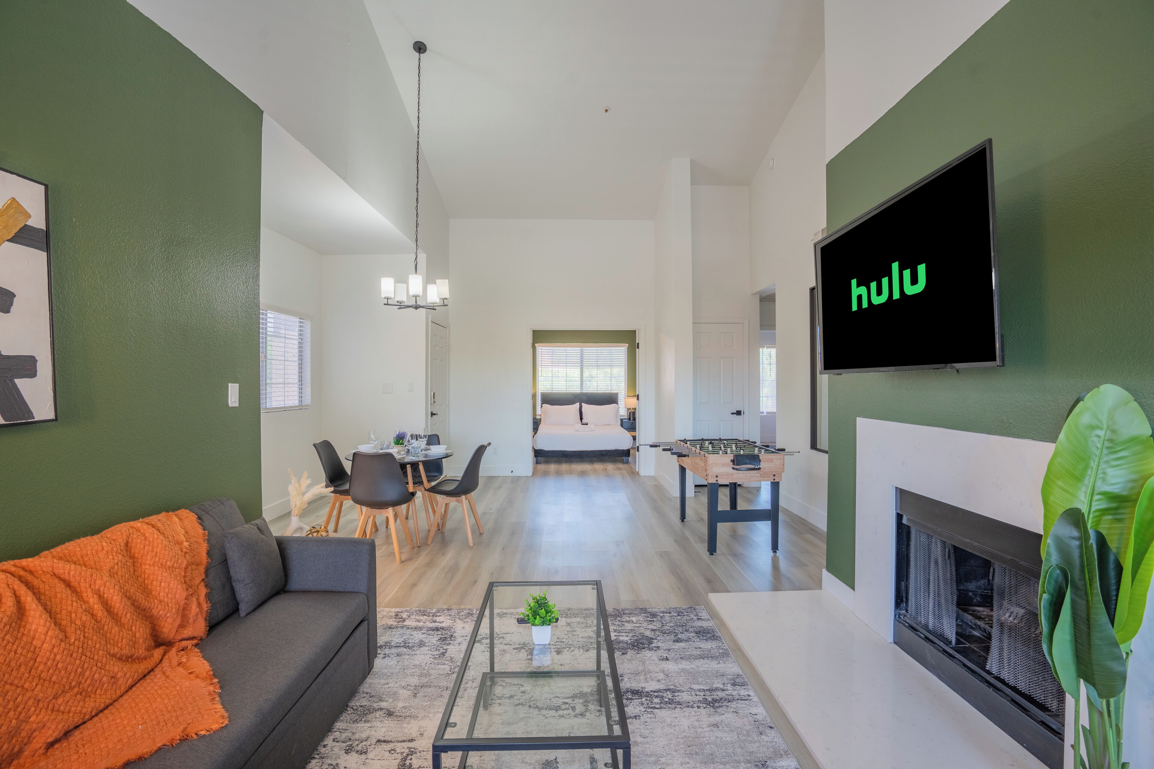 Een moderne woonkamer met een bank, salontafel en een flatscreen televisie waarop 'hulu' wordt getoond.