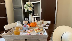 Egy tálca, rajta narancslé, müz és sütemények, egy faasztalon.