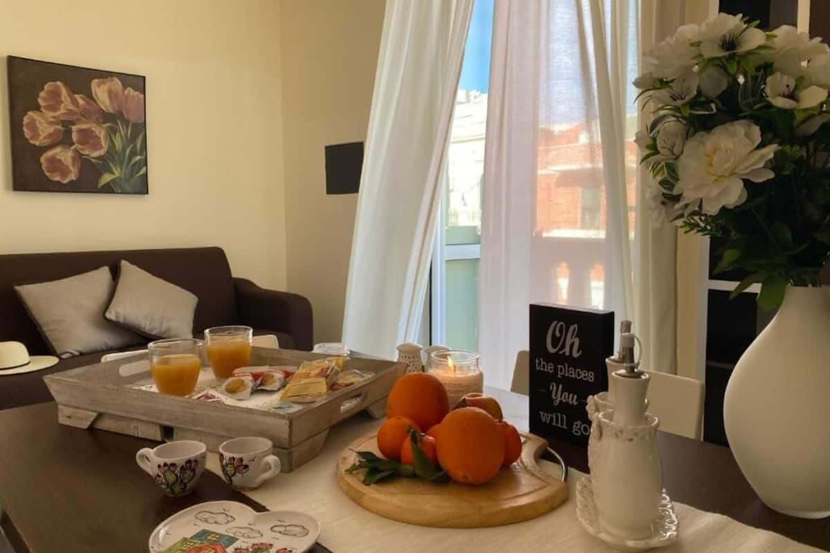A breakfast setup with orange juice, pastries, and a tray on a wooden table.
