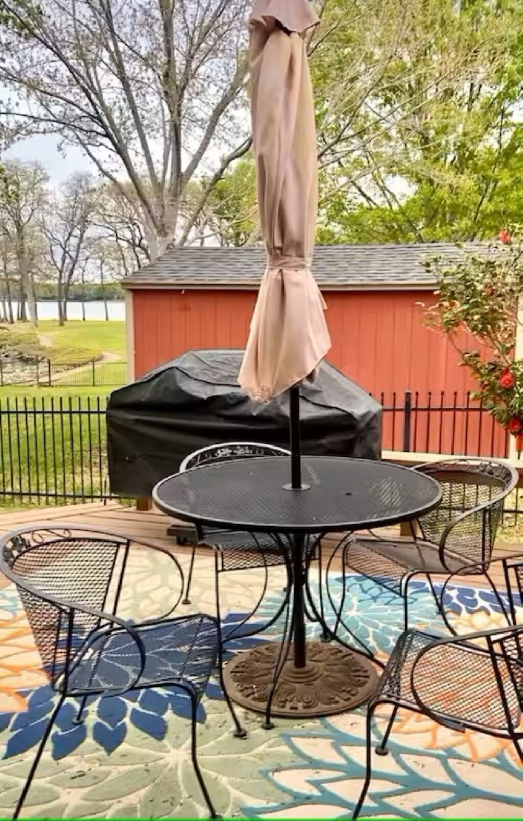 Une terrasse extérieure avec une table ronde et quatre chaises, entourée d’un sol à motifs.