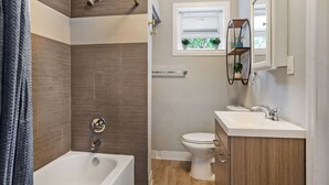 Un baño moderno con bañera, inodoro y tocador.