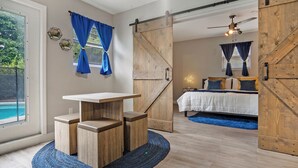 Un dormitorio con cama, escritorio y vistas al exterior.