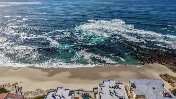 Una playa con vista al océano y un edificio de techo plano.