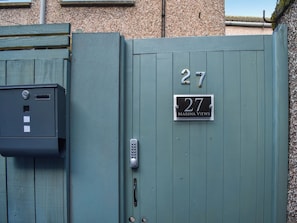 A grey metal gate with a number plate reading "27" and "Marina Views". - Marina Views, your peaceful coastal escape in the heart of Amble. (Morpeth)