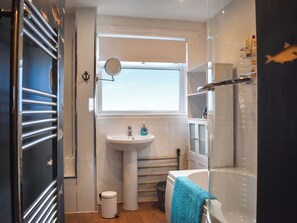 A modern bathroom with a bathtub, a sink, and a window. - Marina Views, your peaceful coastal escape in the heart of Amble. (Morpeth)