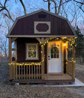 A small wooden cabin with a porch, a door, and a window. - Charming cottage in the countryside with adventure & creative experiences. (Dannebrog)