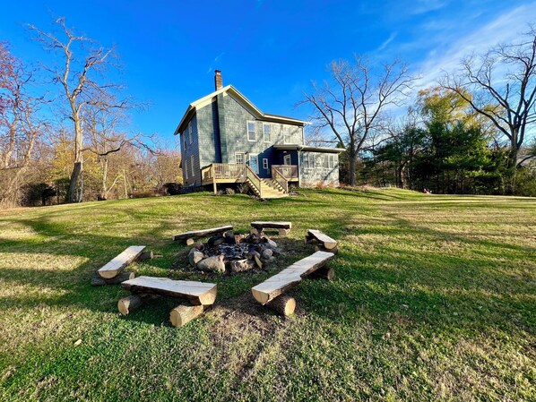 A two-story stone house with a wooden deck and a fire pit in the yard. - The Canandaigua Farmhouse. Private, spacious, with lake access (Canandaigua)
