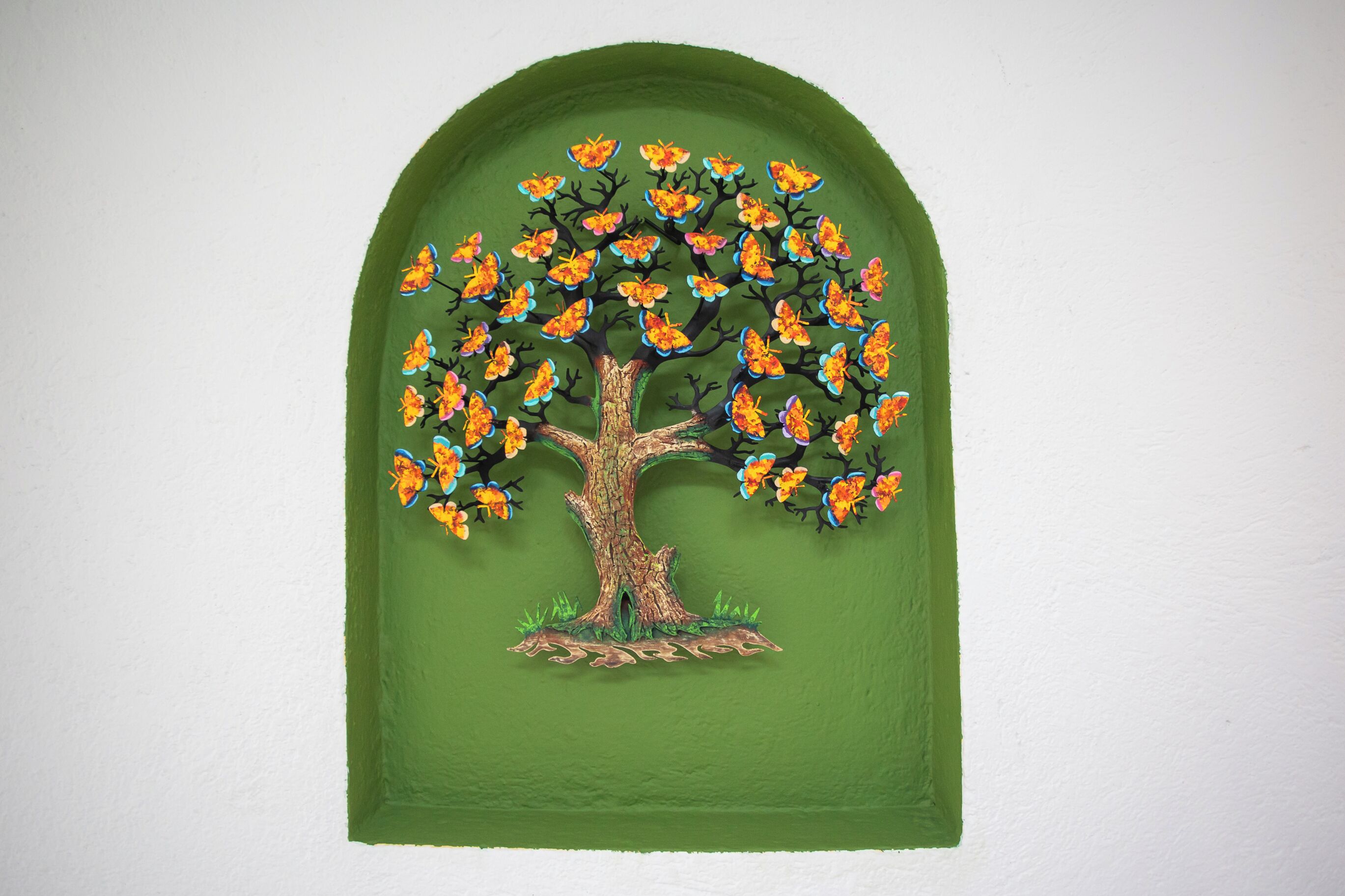 A wall-mounted painting of a tree with orange flowers.