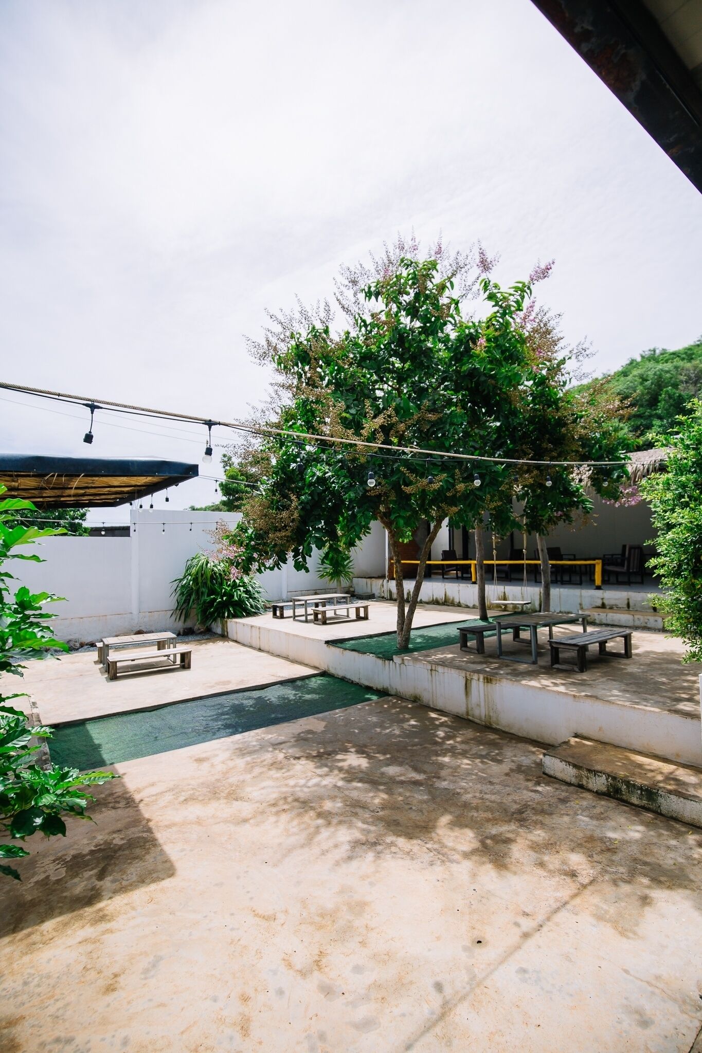Ein Terrassenbereich im Freien mit Pool, Sitzgelegenheiten und einem großen Baum.