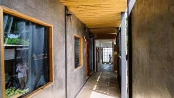 A corridor with a wooden ceiling and large windows.