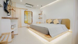 A modern bedroom with a bed, wooden headboard, shelves, and a TV mounted on the wall. - Fan Sea Resort Kohlarn (Koh Lan)