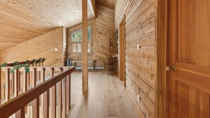 Un intérieur en bois avec un escalier, des murs en bois et une porte.