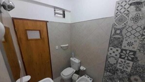 Un baño pequeño con inodoro, bidé y lavamanos.