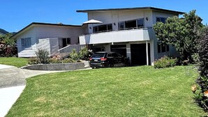 A two-story house with a garage, a driveway, and a well-maintained lawn.