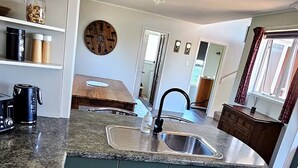 A modern kitchen with a central island, a built-in stove, and a sink.