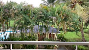A lush garden with palm trees and a small building with a red roof. - In the heart of Guadeloupe 🦋 roots and wings... (Petit-Bourg)