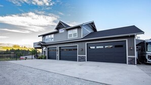 A modern two-story house with a garage, a driveway, and a fenced yard.