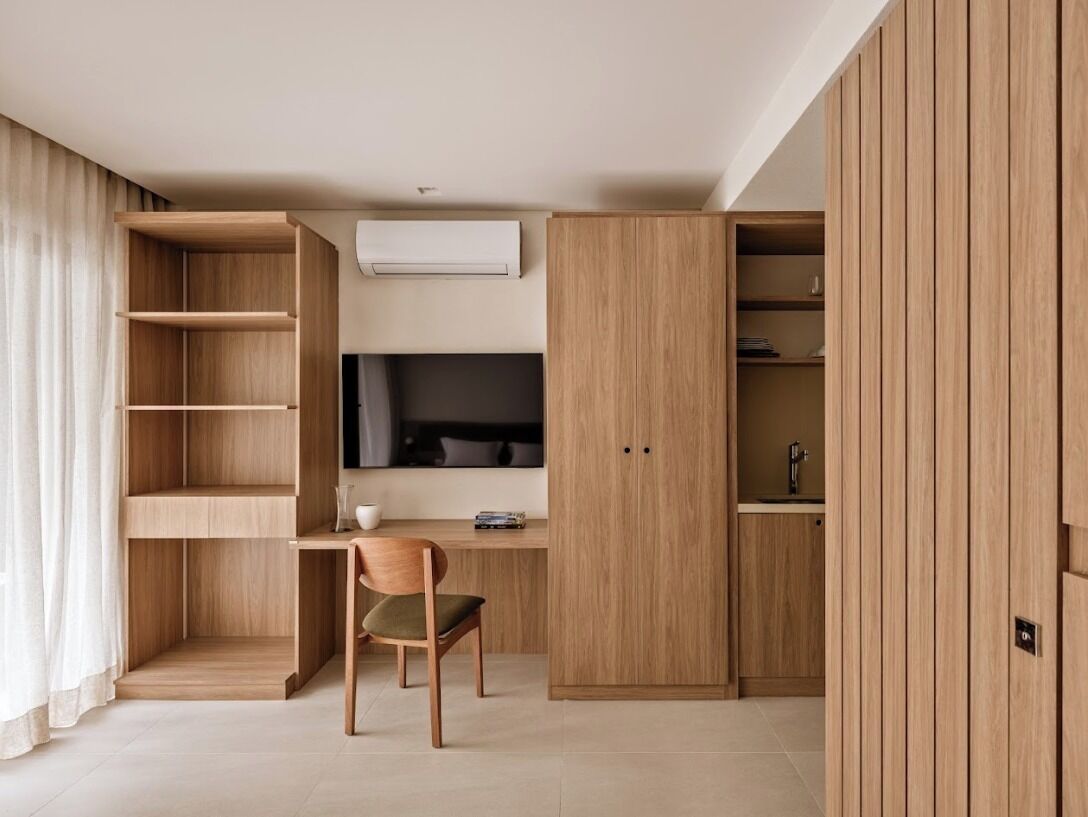 A modern room with a desk, chair, and built-in shelving.