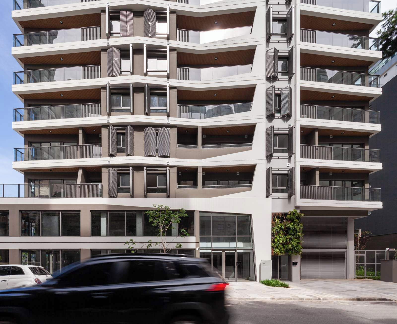 A multi-story residential building with balconies, large windows, and a modern architectural design.