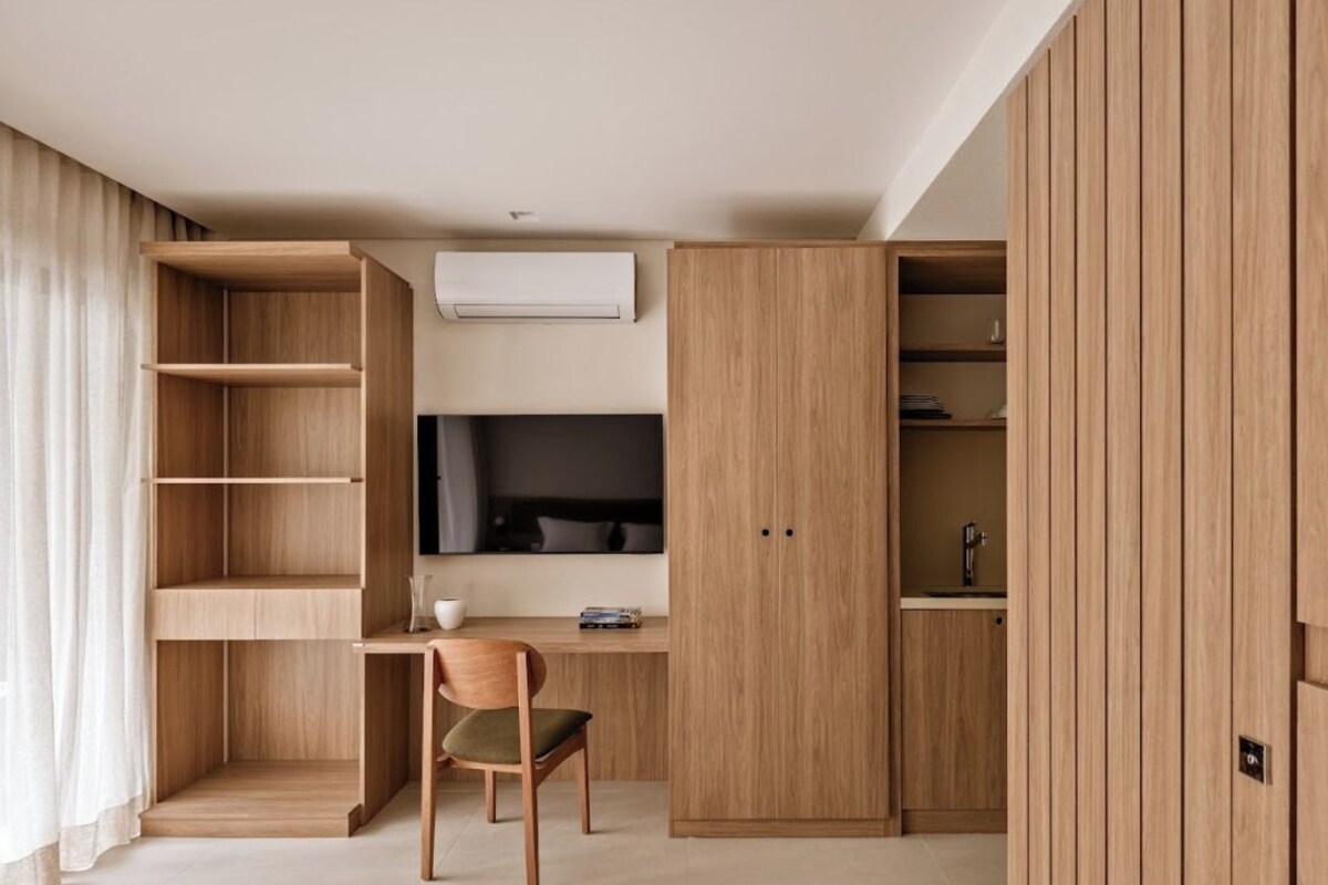 Ein modernes Zimmer mit Schreibtisch, Stuhl und integrierten Regalen.
