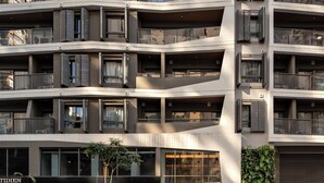 A multi-story residential building with balconies, a storefront, and parked cars. - Aloe Vila Nova Conceição (São Paulo)