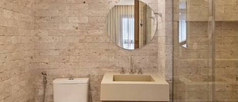 Un bagno con il water, un lavandino con uno specchio sopra e una doccia.