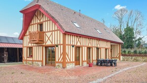 Ein traditionelles Fachwerkhäuschen mit rotem Dach, Steinunterbau und einem Balkon mit Holzgeländern.