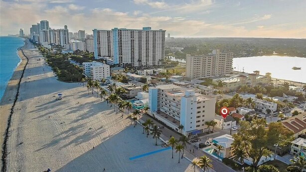 Una zona urbana costera con rascacielos, una playa y un puerto deportivo.