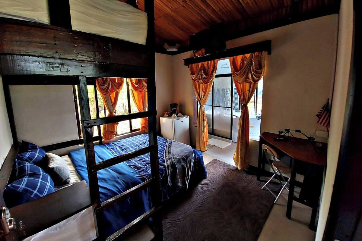 Una habitación con literas, un escritorio y una ventana con cortinas.