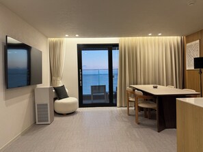 Attico, balcone, vista mare | Area soggiorno | Smart TV 65 pollici con canali via cavo, Netflix, servizi in streaming