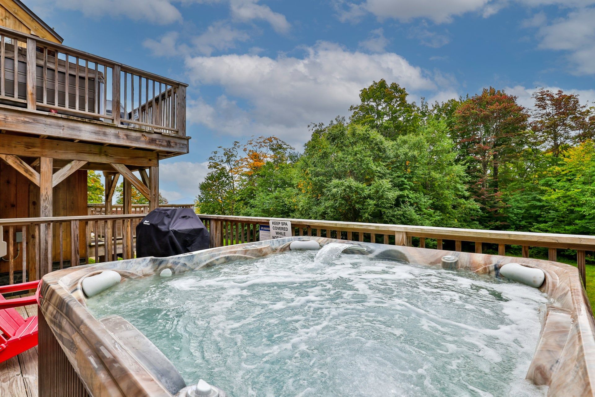 Ein Whirlpool mit einer Holterrasse und einem Schild, das anzeigt, dass er Teil des Spa-Bereichs ist.