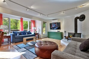 Ein modernes Wohnzimmer mit einer Couch, einem Hocker und einem Kamin.