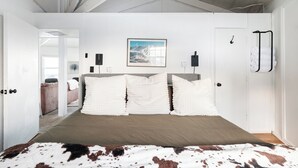 A bedroom with a bed, a door, a towel rack, and a framed picture on the wall. - Classic | Ski-in/Out | Views | PetFriendly | 2BR (Beech Mountain)