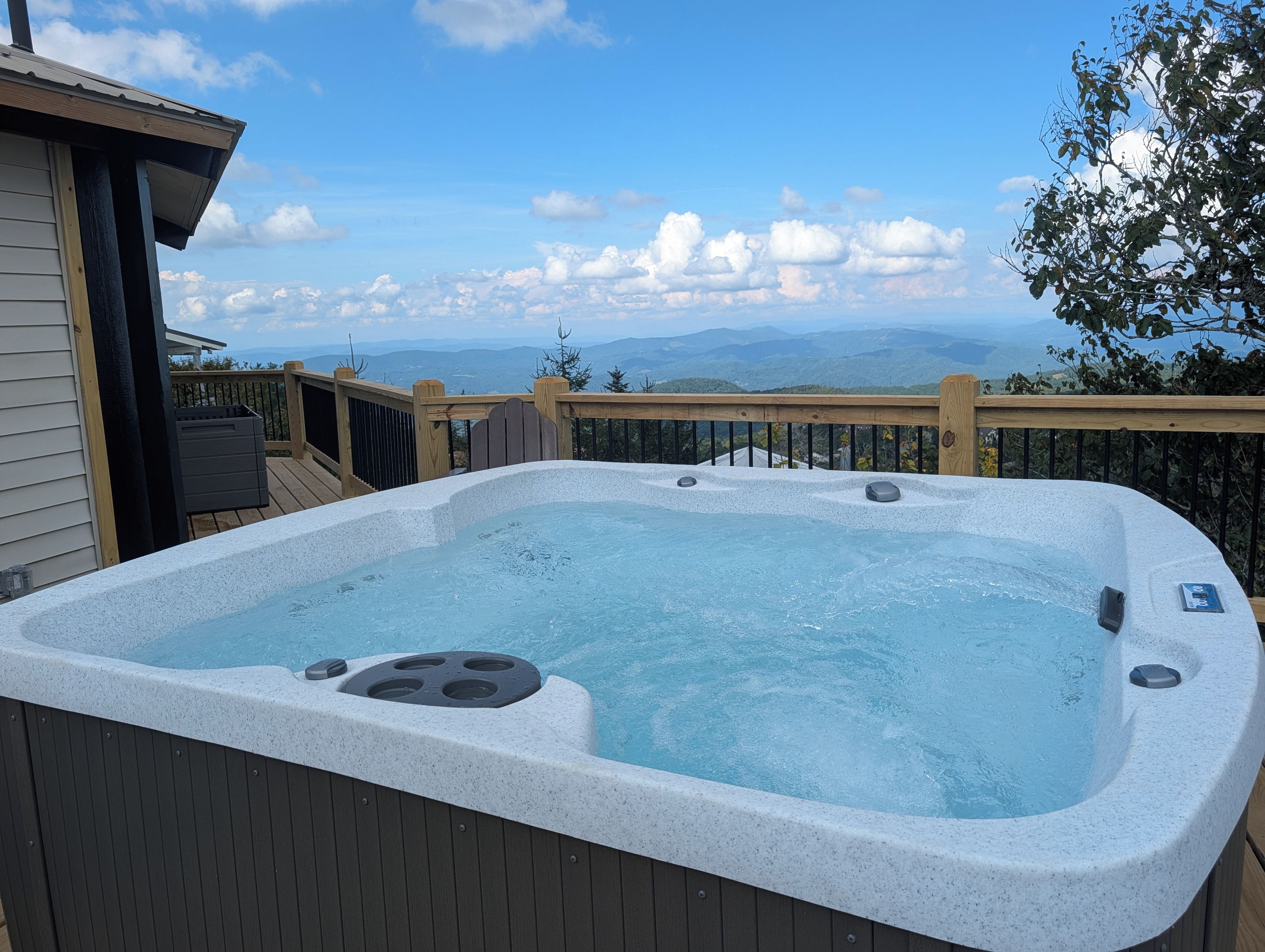 Un jacuzzi en una terraza con vistas a las montañas.