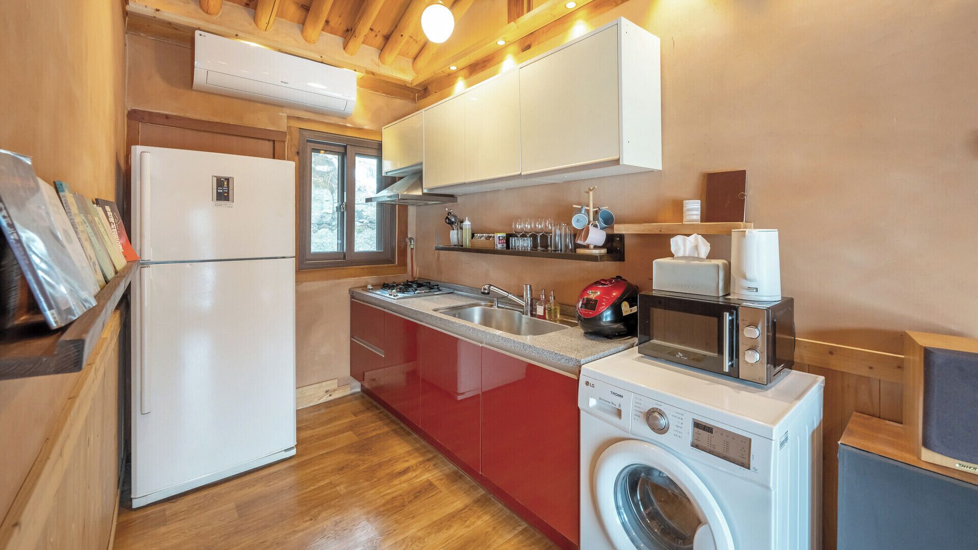 A compact kitchen with a washing machine, a microwave, and a coffee maker.