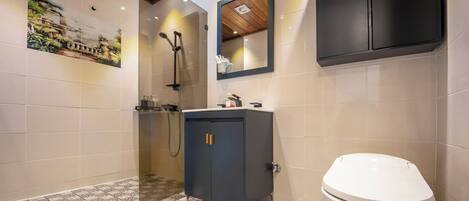 Ein Badezimmer mit Dusche, Waschbecken, Toilette und Spiegel.