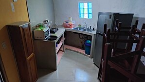 A compact kitchen with a sink, stove, and refrigerator. - Cozy 2-bedroom townhome in charming Provincia de Puntarenas with AC, WiFi (Provincia de Puntarenas)