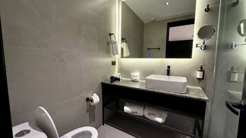 A modern bathroom with a toilet, sink, and shower.