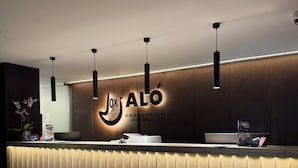 Modernilla designilla varustettu vastaanottotiski, jossa on selkeästi esillä logo ja nimi »Jox ALÓ».