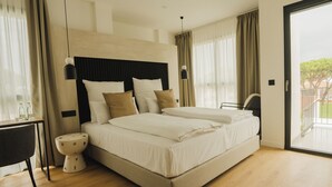 Une chambre d’hôtel moderne avec un grand lit, des tables de chevet et une vue sur l’extérieur.