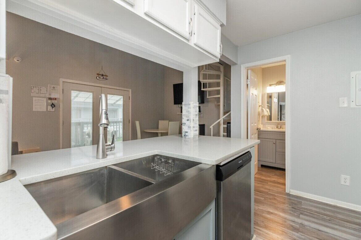 A modern kitchen with stainless steel appliances, a double sink, and a dishwasher.