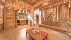 Una cocina rústica con vigas de madera, pared de ladrillo y un ventanal grande.