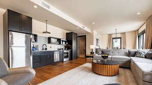 Cocina moderna con armarios oscuros, electrodomésticos de acero inoxidable y una isla central.
