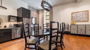 Una cocina moderna con armarios oscuros, una isla central y un área de comedor con una mesa redonda y sillas.