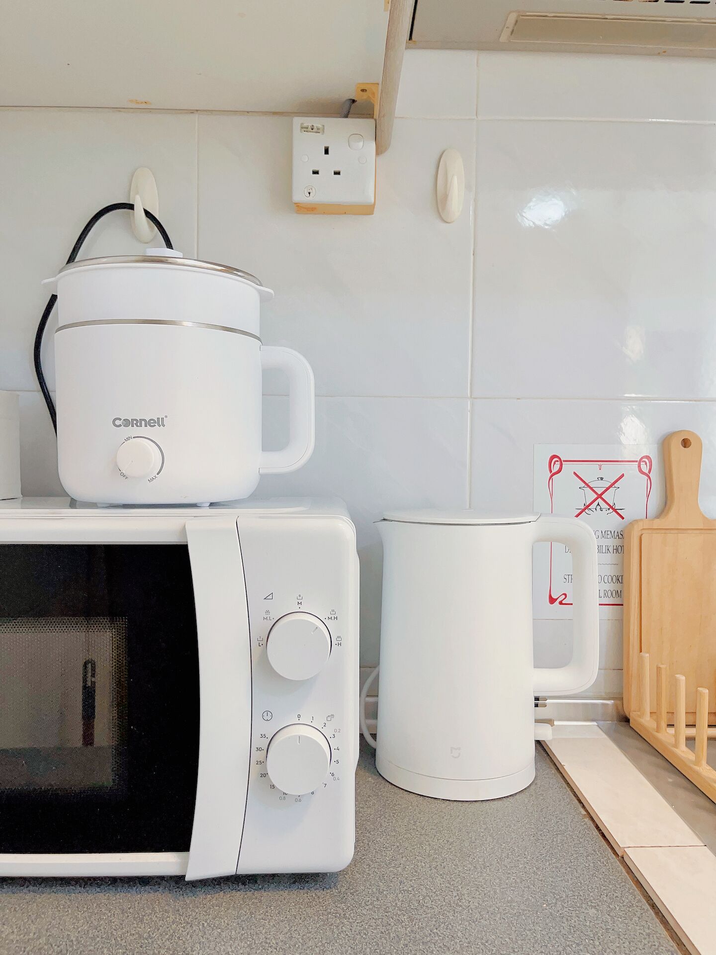 A kitchen with a microwave, a slow cooker, and a coffee maker.