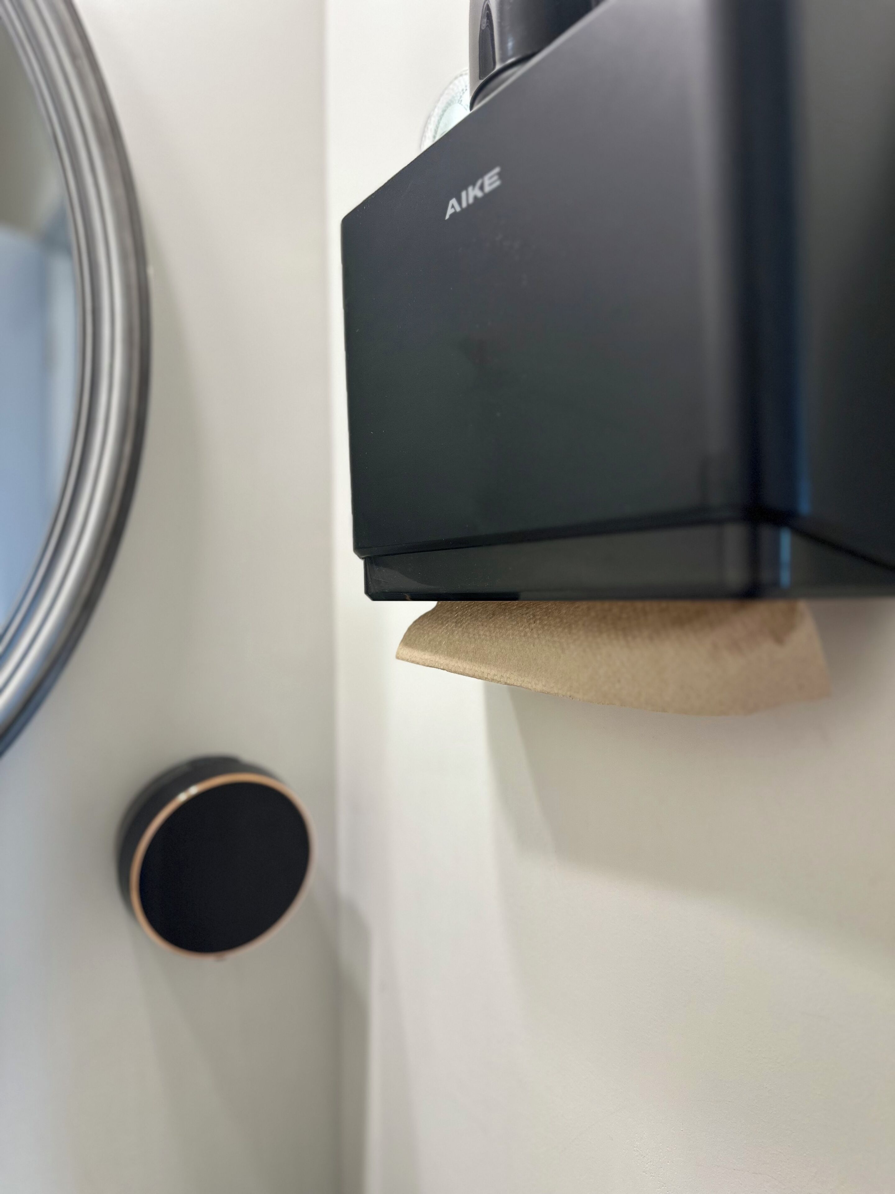 A black electronic device with the brand name 'AIKE' mounted on a wall.