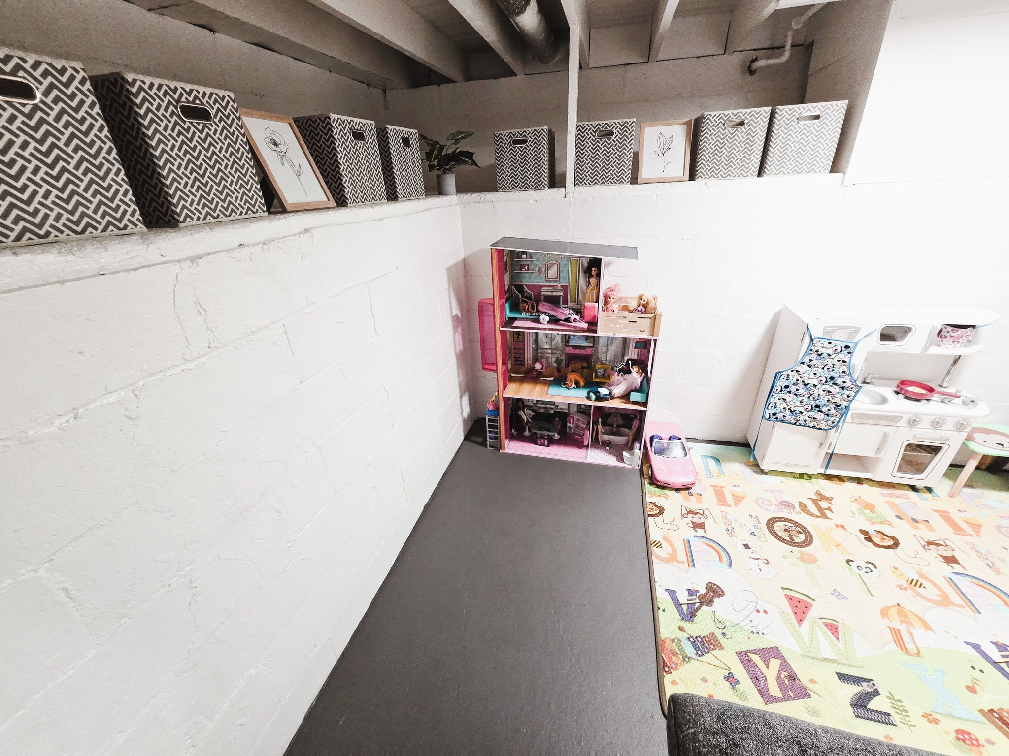 Una casa de muñecas con varias habitaciones, una pequeña mesa y un suelo estampado.