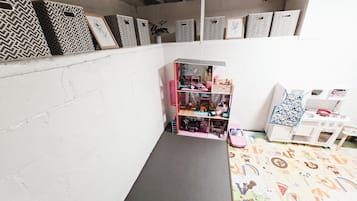 Una casa de muñecas con varias habitaciones, una pequeña mesa y un suelo estampado.